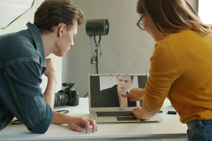 Two colleagues working through software on a laptop