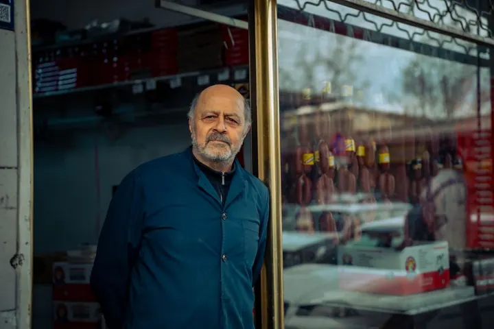Family business owner standing in front of his shop